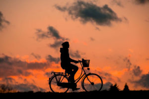 en person som cyklar i solnedgången
